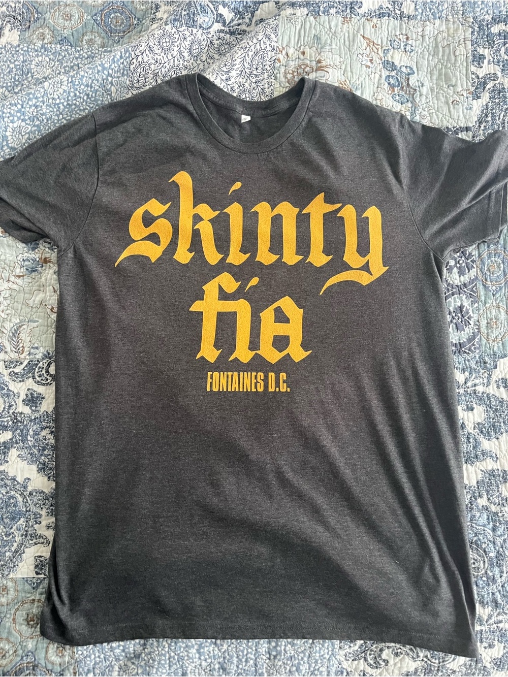 Fontaine’s DC Charcoal T‑Shirt with Yellow 'Skinty Fia' Print